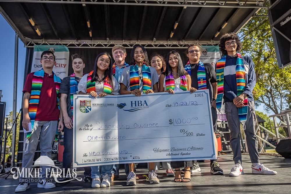 New Braunfels Dia de Los Muertos Festival scholarship award ceremony on stage with recipients and Hispanic Business Alliance